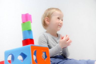 Küçük çocuk üç yaşında masada oturur ve plas ile çalış