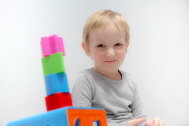 Küçük çocuk üç yaşında masada oturur ve plas ile çalış