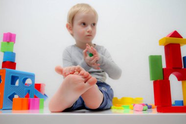 Küçük çocuk üç yaşında masada oturur ve plas ile çalış