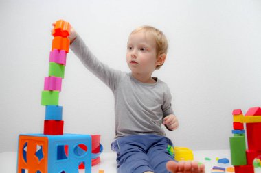 Küçük çocuk üç yaşında masada oturur ve plas ile çalış