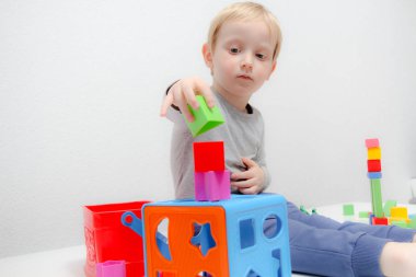 Küçük çocuk üç yaşında masada oturur ve plas ile çalış