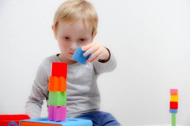 Küçük çocuk üç yaşında masada oturur ve plas ile çalış