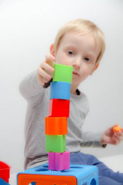 Küçük çocuk üç yaşında masada oturur ve plas ile çalış