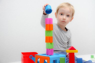 Küçük çocuk üç yaşında masada oturur ve plas ile çalış