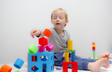 Küçük çocuk üç yaşında masada oturur ve plas ile çalış