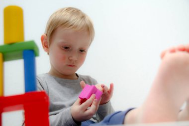 Küçük çocuk üç yaşında masada oturur ve plas ile çalış