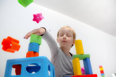 Küçük çocuk üç yaşında masada oturur ve plas ile çalış