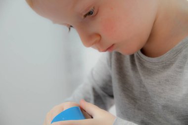 Küçük çocuk üç yaşında masada oturur ve plas ile çalış