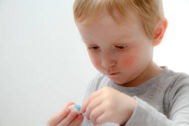Küçük çocuk üç yaşında masada oturur ve plas ile çalış