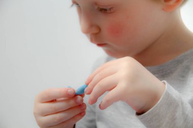 Küçük çocuk üç yaşında masada oturur ve plas ile çalış