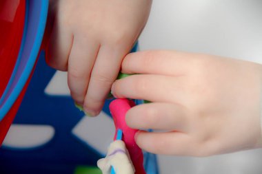 Küçük çocuk üç yaşında masada oturur ve plas ile çalış