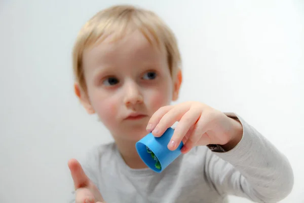 Kleiner Junge von drei Jahren sitzt auf dem Tisch und spielt mit Plas — Stockfoto