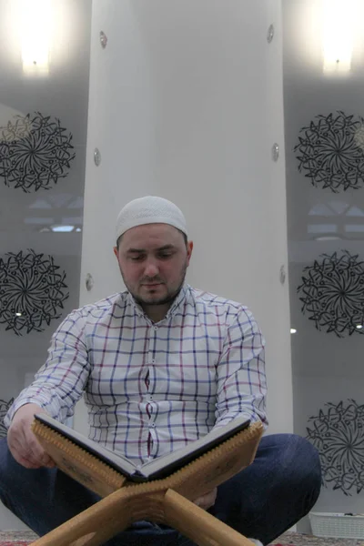 Giovane musulmano che legge il Corano - libro sacro dei musulmani — Foto Stock
