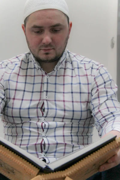 Joven musulmán leyendo el Corán - libro sagrado de los musulmanes — Foto de Stock