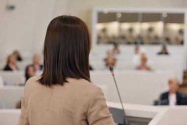 Toplantısında konuşan bir iş kadını. İzleyici olarak conferenc