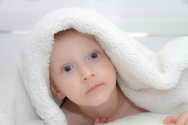 Güzel çocuk yorganın altından dışarı bakıyor