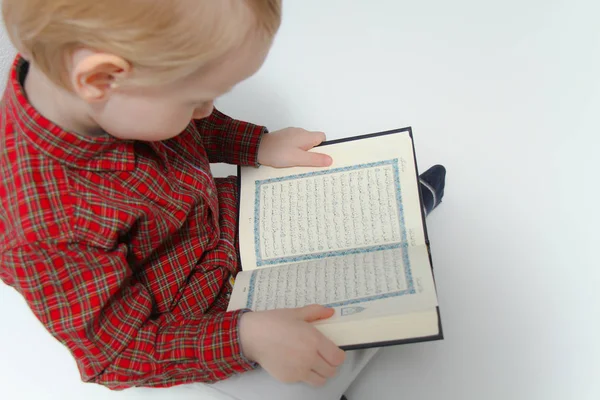 Малий муслім, європейський хлопчик з ісламічною святою книгою Коран або Куран — стокове фото