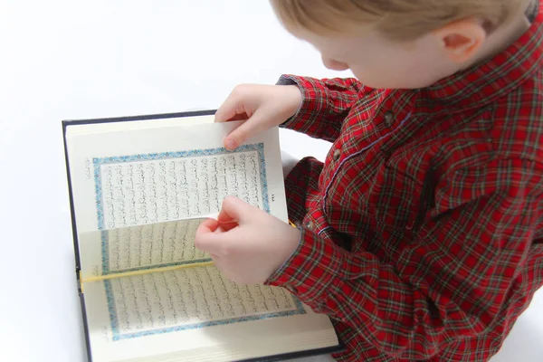 Mały muzułmanin europejski chłopiec z islamską świętą księgą Koran lub Kuran — Zdjęcie stockowe