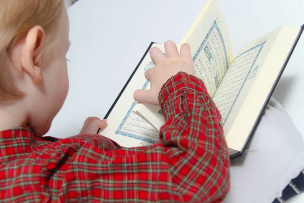 Pequeño niño musulmán europeo con libro sagrado islámico Corán o Kurán — Foto de Stock