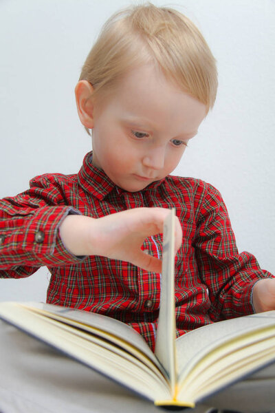 Little muslim European boy with islamic holy book Quran or Kuran