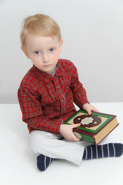 Mały muzułmanin europejski chłopiec z islamską świętą księgą Koran lub Kuran — Zdjęcie stockowe