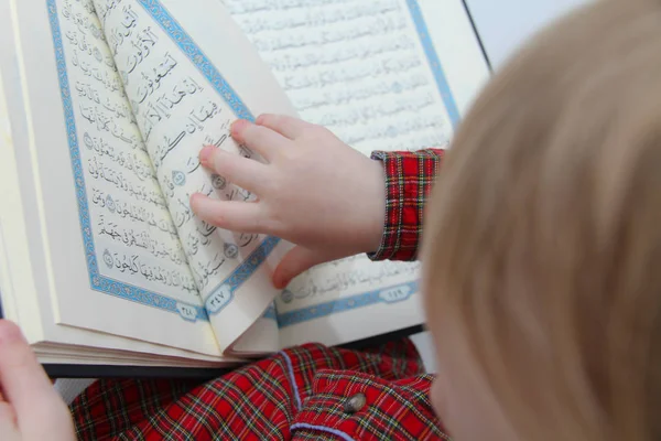 Kleine moslim Europese jongen met islamitisch heilig boek Koran of Kuran — Stockfoto