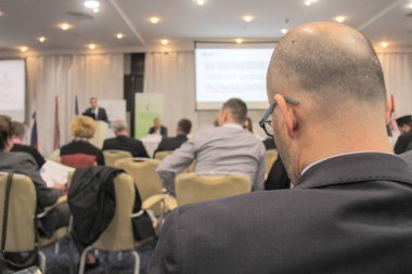 Video konferansı sırasında konferans salonunda ya da salonda oturan iş adamları 