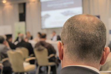 Video konferansı sırasında konferans salonunda ya da salonda oturan iş adamları 