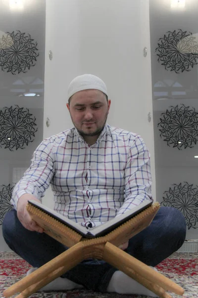 Joven musulmán leyendo el Corán - libro sagrado de los musulmanes —  Fotos de Stock