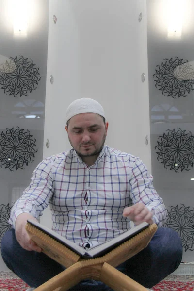 Jovem muçulmano lendo o Alcorão - livro sagrado dos muçulmanos — Fotografia de Stock
