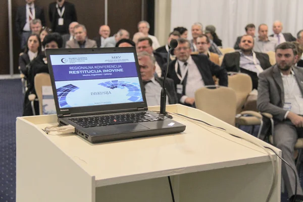 Businesspeople during video conference sitting in conference room or hall