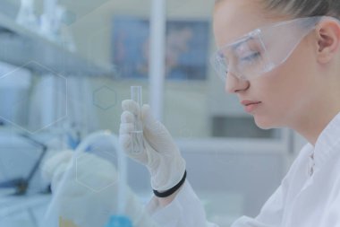 Genç kadın bilim adamı laboratuarda deneyler yapıyor.