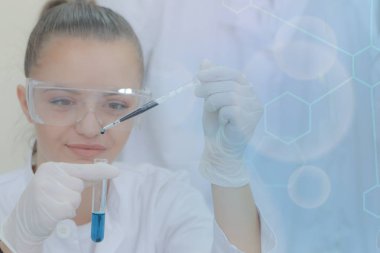 Genç kadın bilim adamı laboratuarda deneyler yapıyor.