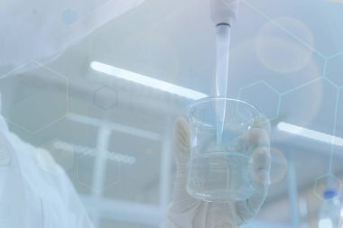 Genç bayan bilim adamı laboratuarda deneyler yapıyor, yakın plan.