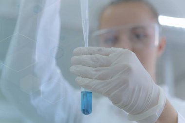 Genç kadın bilim adamı laboratuarda deneyler yapıyor.