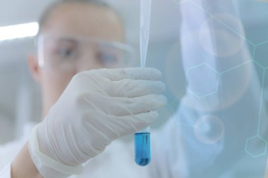 Genç kadın bilim adamı laboratuarda deneyler yapıyor.