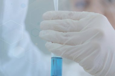 Genç kadın bilim adamı laboratuarda deneyler yapıyor.