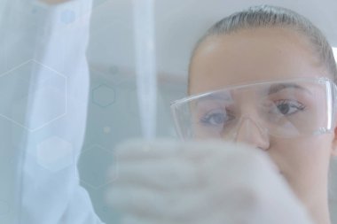 Genç kadın bilim adamı laboratuarda deneyler yapıyor.