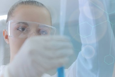 Laboratuvarda test tüpleriyle çalışan genç kadın laboratuvar bilim adamı.