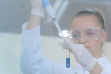 Laboratuvarda test tüpleriyle çalışan genç kadın laboratuvar bilim adamı.