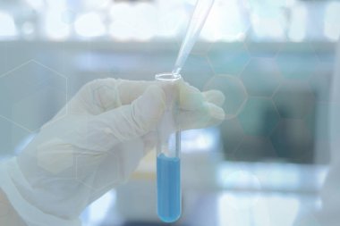 Laboratuvarda test tüpleriyle çalışan genç kadın laboratuvar bilim adamı.