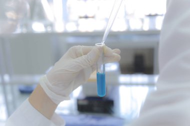 Laboratuvarda test tüpleriyle çalışan genç kadın laboratuvar bilim adamı.