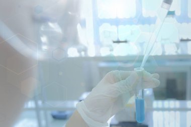 Laboratuvarda test tüpleriyle çalışan genç kadın laboratuvar bilim adamı.