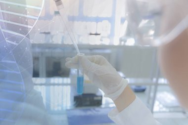 Laboratuvarda test tüpleriyle çalışan genç kadın laboratuvar bilim adamı.