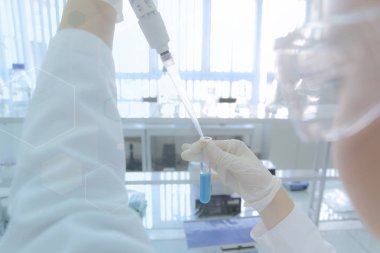 Laboratuvarda test tüpleriyle çalışan genç kadın laboratuvar bilim adamı.