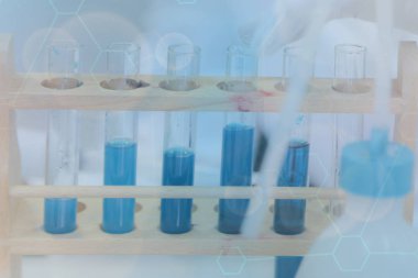 Laboratuvarda test tüpleri ve test tüpleriyle çalışan genç bir bilim adamı. 