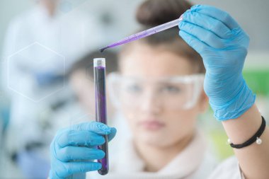 Laboratuvarda test tüpleriyle çalışan genç kadın laboratuvar bilim adamı.