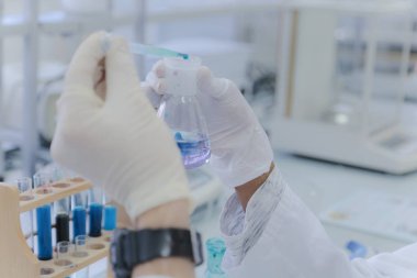 Laboratuvarda test tüpleriyle çalışan genç kadın laboratuvar bilim adamı.