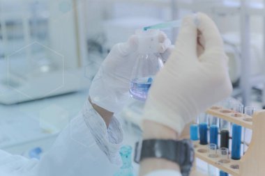 Laboratuvarda test tüpleriyle çalışan genç kadın laboratuvar bilim adamı.