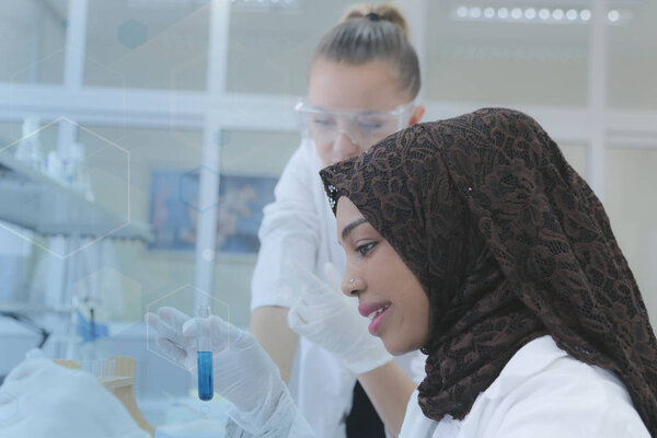 Two multiethnic young female scientists doing experiments in lab